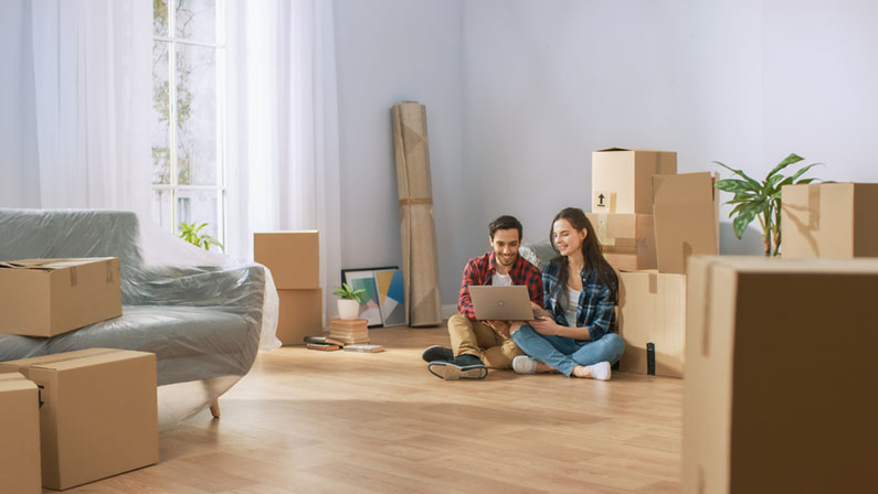 couple sitting with boxes in living room